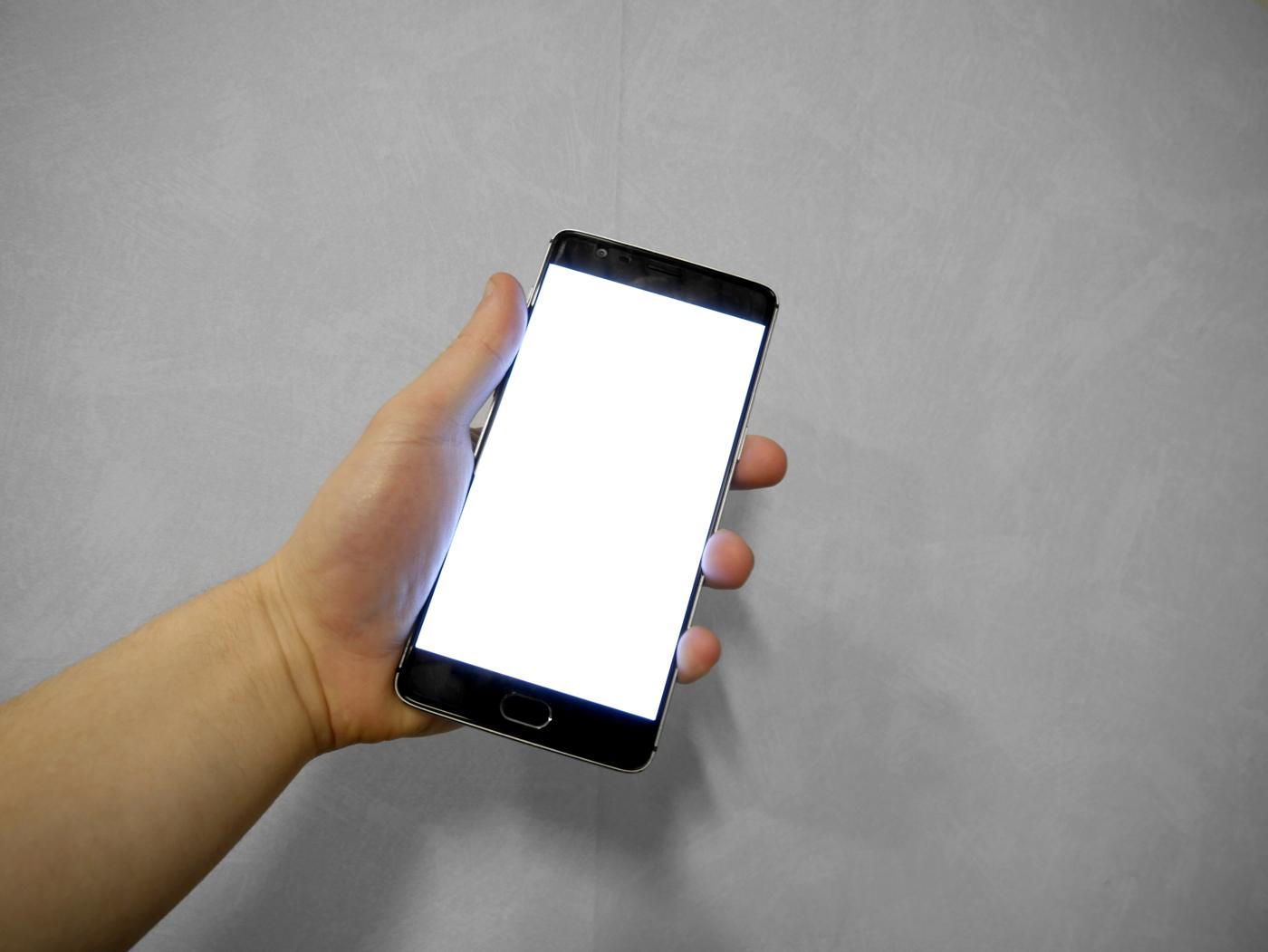 Mão segurando um celular com a tela em branco